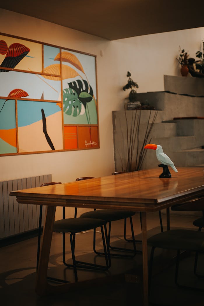 Wooden table with a toy bird and colorful wall art in a modern Ankara interior.