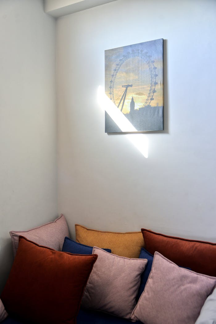 Inviting nook with warm cushions and wall art, perfect for relaxation.